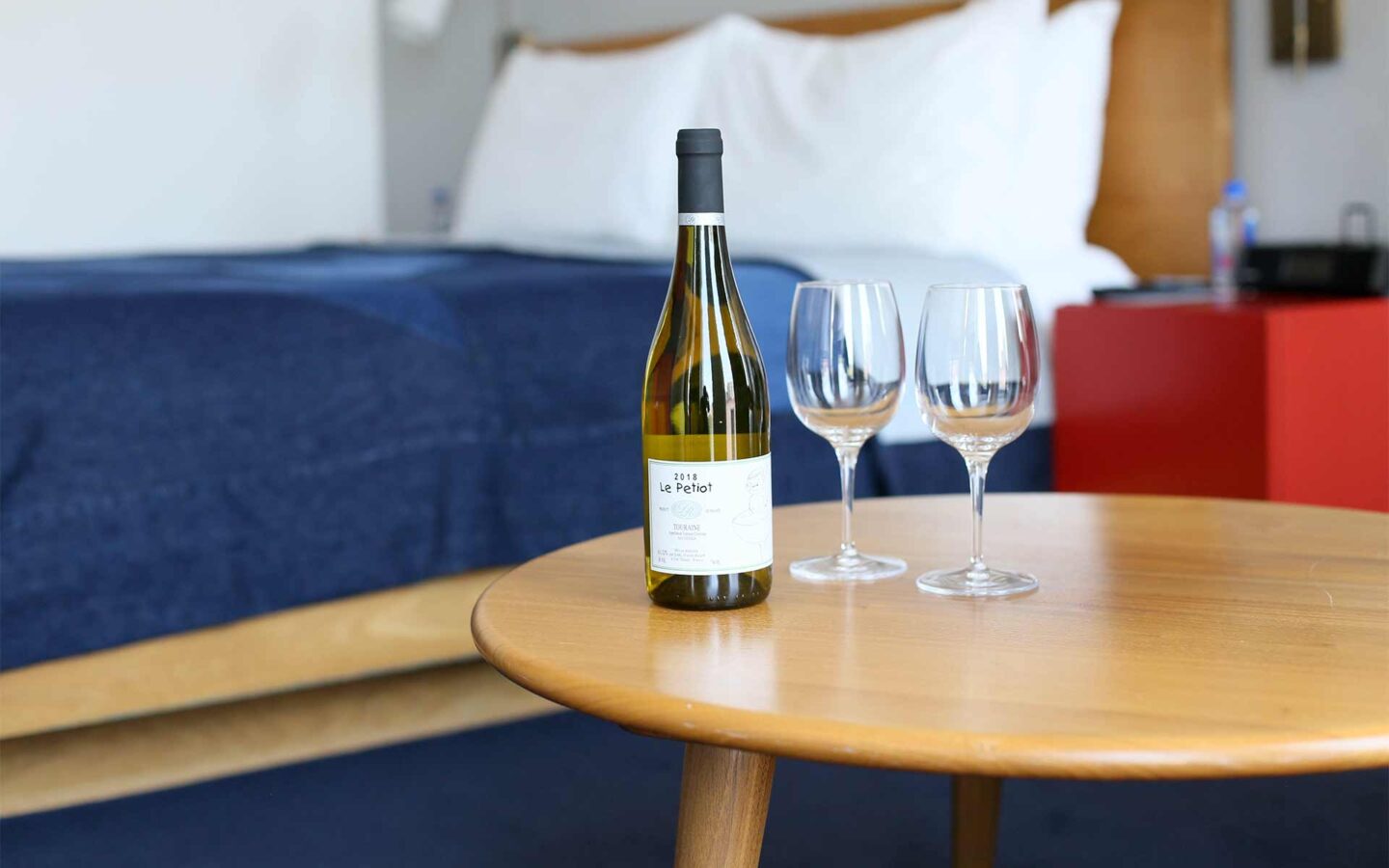 two wine glasses next to a bottle of white wine on a coffee table
