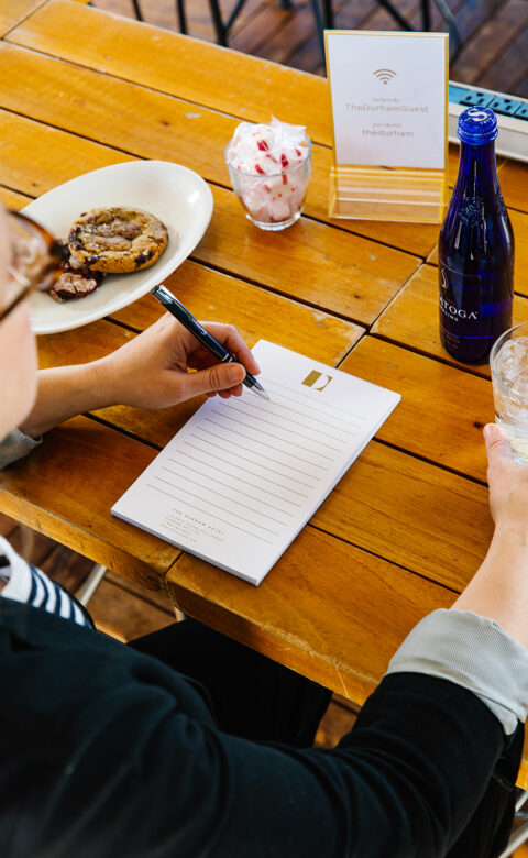 woman sitting at meeting table taking notes