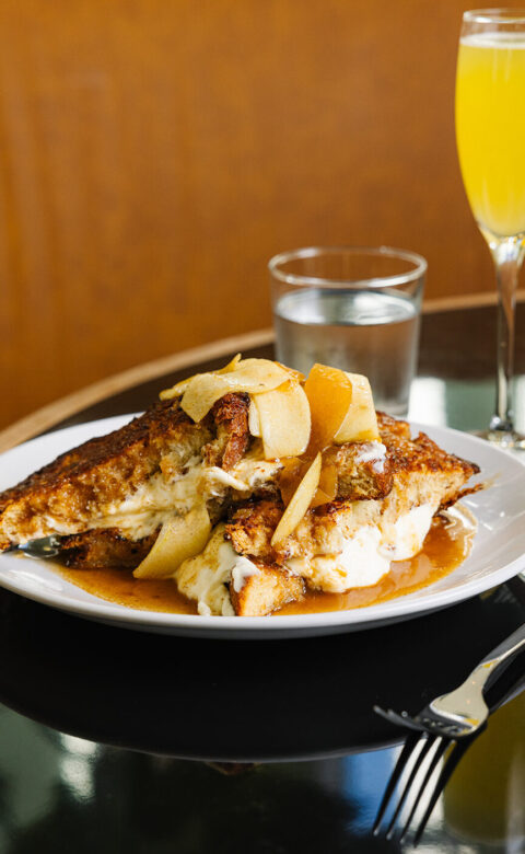 a white plate topped with food next to a glass of orange juice